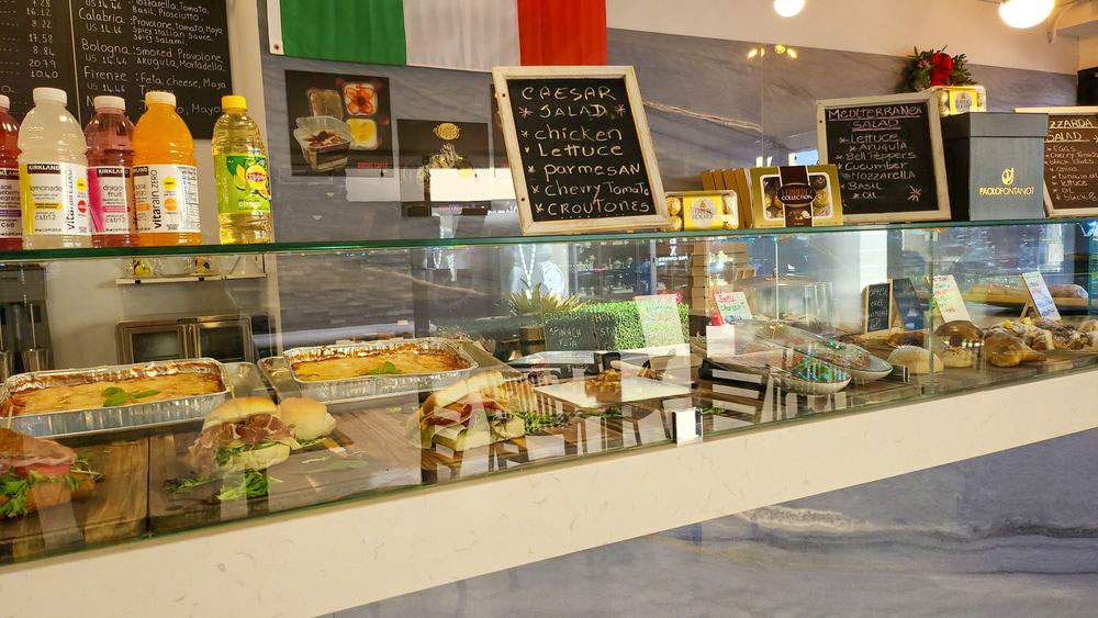 Glass display case full of pastries, focaccia, and Italian panini